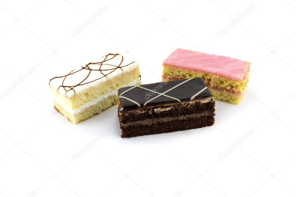 three sponge cakes in chocolate, white and pink glaze close-up, isolated on a white background