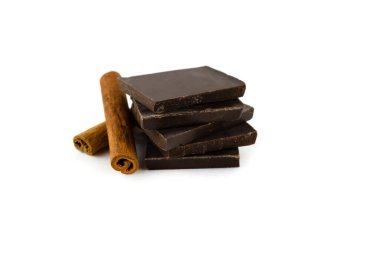 Koyu çikolata parçaları ve tarçın çubukları beyaz arka planda izole bir şekilde yakın çekim yaparlar.