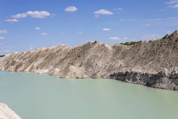 natural clear water at the foot of a chalk quarry against a blue sky landscape