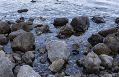 Dağlardan düşüp deniz manzarasına düşen büyük taşlar.