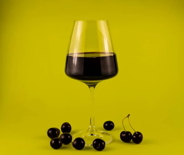 Verre Vin Rouge Avec Une Dispersion Cerises Sur Fond Vert — Photo