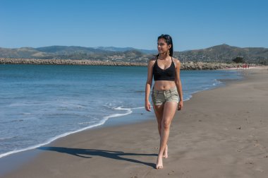 Plaj boyunca strolling genç kadın