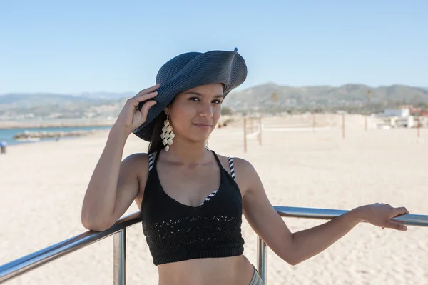 Mujer joven posando en su sombrero de playa — Foto de Stock