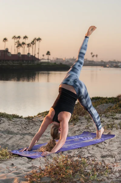 Mujer en mallas patrón mostrando equilibrio y fuerza al amanecer . —  Fotos de Stock