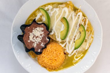 Pirinç ve kızarmış fasulye ile servis edilen enchiladas Suizas 'ın genel manzarası..