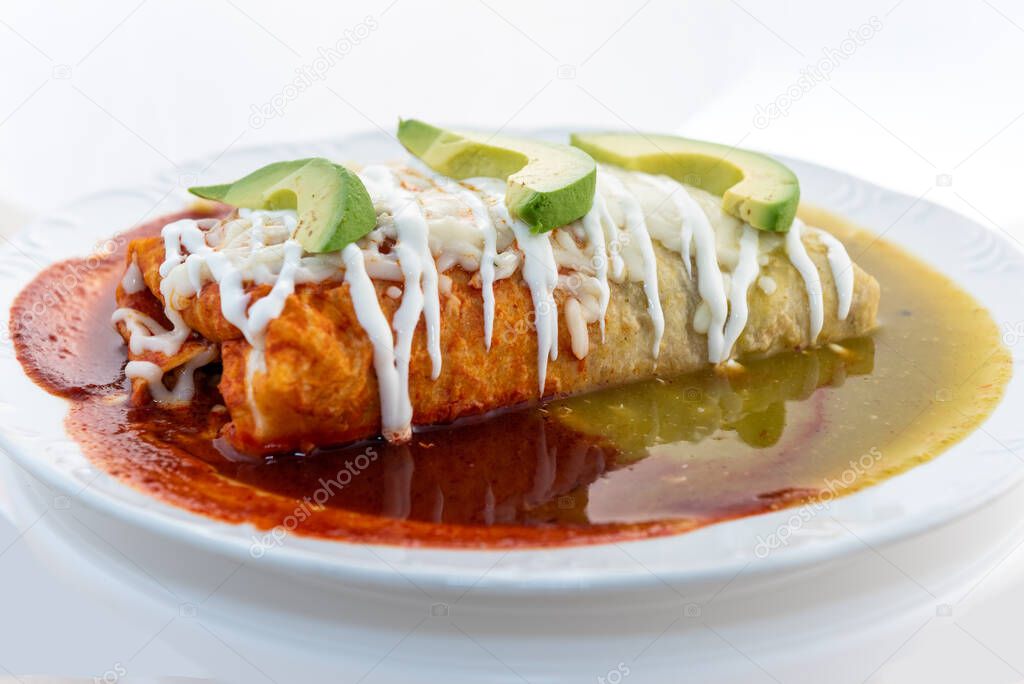 Three colored wet burrito served in red and green sauce, looks and tastes appealing.