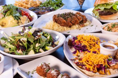 Bistro 'nun lezzetli tabakları ile çevrili balık tacoları masada açık büfe stilinde servis edilir..