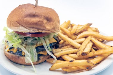 Çifte çizburger, marul, domates, patates kızartması ile servis edilen tat alma tomurcukları..