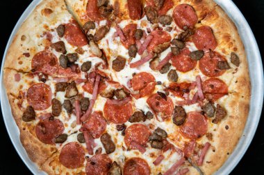 Pepperoni, sosis, pastırma ve jambonun genel manzarası bütün pizzayı kaplayan etlerdir..