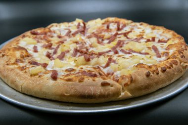 Keskin ananas, özel lezzet için eritilmiş peynirli Hawaii pizzasının tepesinde..