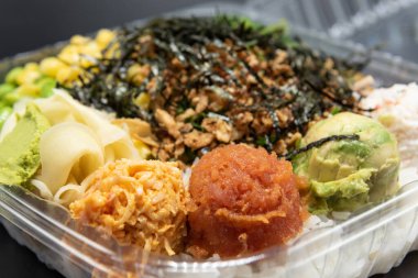 Karides tempurası, yengeç eti, ödem ve mısır ile kaplı üç top dürtme ile büyük bir paket servis plastik kasesi servis edilir..