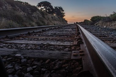 Paralel tren rayları, şafak vakti gökyüzünü aydınlatmaya başladığında ufka çıkar..