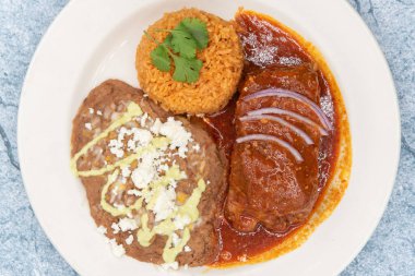 Kırmızı sosla ıslanmış Şili Colorado 'nun büyük et, yeniden kızartılmış fasulye ve pilavının genel manzarası..