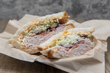 Ekşi ekmeğin içine istiflenmiş kızarmış hindi sandviçi et, dolgu malzemesi ve doğranmış lahanayla dolu..