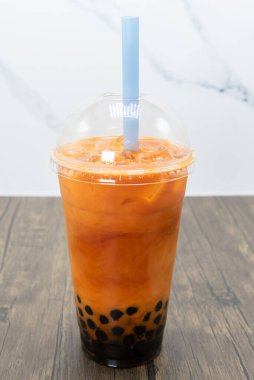 Tay çayı boba smoothie, tapyoka toplarının kolayca geçmesi için kalın bir pipetle soğuk servis edilir..