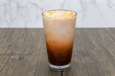 Buzlu Tayland çayının tüm katmanları uzun bir bardakta soğuk içecek olarak servis edilir..