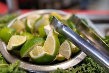 Limon dilimleri çeyrekliklere bölünmüş ve Meksika yemeği olarak Meksika salsa barına maşa ile servis edilmiş..