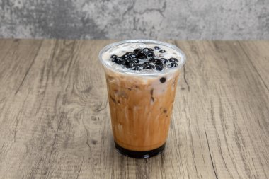 Kahverengi şekerli sütlü içecek soğuk içecek ferahlatıcı bir içecek için buzlu boba içeceği karıştırır.