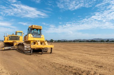 Ağır derecelendirme araçları zorlu bir iş gününden sonra dinleniyor. Tarla arazisini kontraksiyon seviyesine düşürüyor..