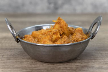 Hint restoranındaki bir kasedeki köri aromalı tavuk eti mükemmel pişmiş ve baharatlı..