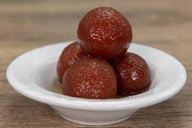 Hint restoranından gelen tatlı için düzgünce dizilmiş yuvarlak gulab jamonları mükemmel pişirilmiş ve baharatlı..