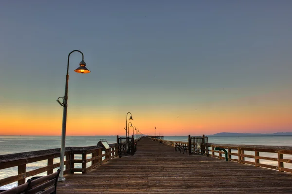 Sunrise lamps on the old wooden pier — Stock Photo, Image