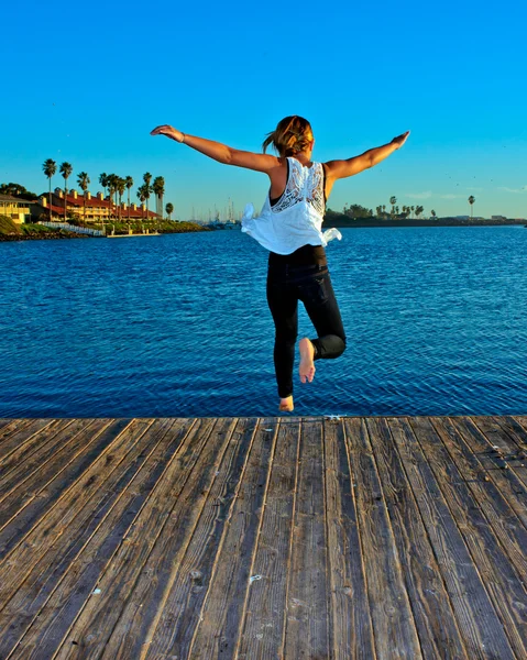 Girl jumping off the dock — Stock Photo, Image