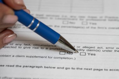 Evet ya da hayır cevabını belirlemek için soru formunda bir kalem tutan kadınsı parmaklar..