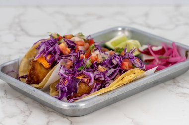 Aç bir patron için latin yemeği bir çift ızgara balık tacosu içerir..