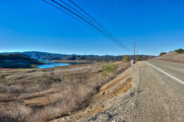Estrada rural ao longo do lago de baixo nível . — Fotografia de Stock