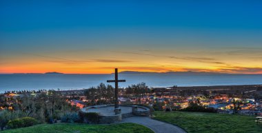 Cross landmark over city lights of Ventura clipart