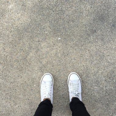 Beyaz spor ayakkabı ayakkabı zemin üstüne yürüyüş görüntülemek