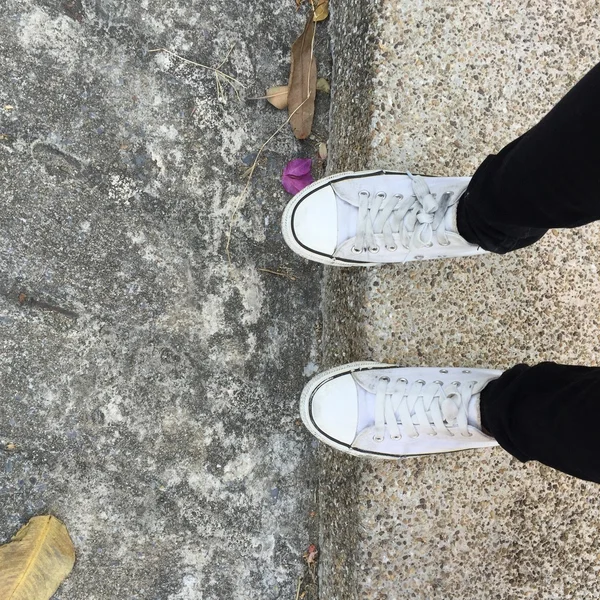 Witte Sneakers schoenen lopen op de grond boven bekijken — Stockfoto