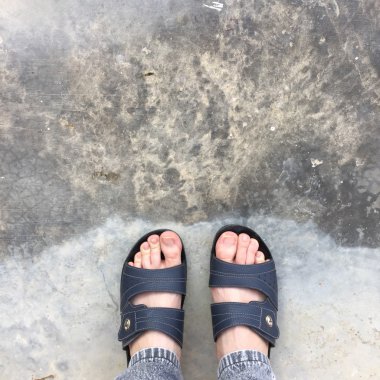 Eski Concreat üzerinde duran soyut Feet ayakkabı. Flip flop Hipster 