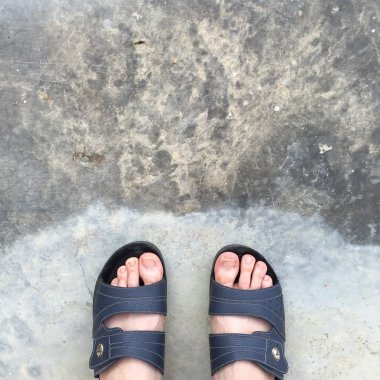 Eski Concreat üzerinde duran soyut Feet ayakkabı. Flip flop Hipster 