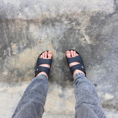 Eski Concreat üzerinde duran soyut Feet ayakkabı. Flip flop Hipster 