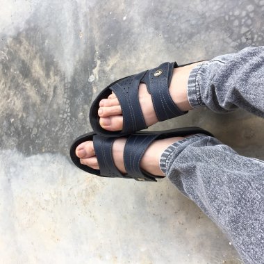 Eski Concreat üzerinde duran soyut Feet ayakkabı. Flip flop Hipster 