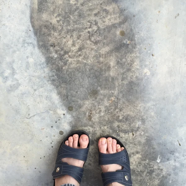 Abstraktní nohou boty na starých Concreat. Žabky bederní — Stock fotografie