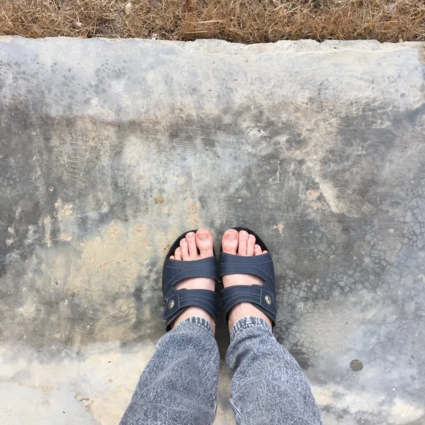 Abstracte voeten schoenen staande op de oude Concreat. Flip Flops Hipster — Stockfoto