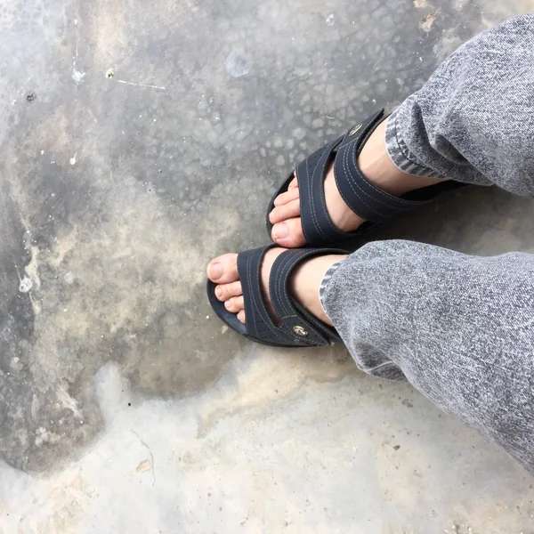 Scarpe astratte piedi in piedi su vecchio calcestruzzo. Infradito Hipster — Foto Stock