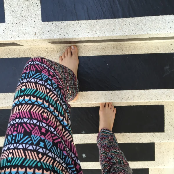 Walking upstairs: close-up view of woman's feet