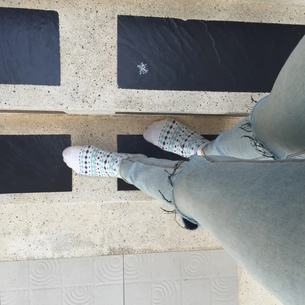 Selfie feet wearing socks on staircase backgzround, jeans and feet