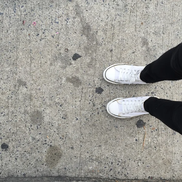 White sneakers on girl legs on the background — Stock Photo, Image