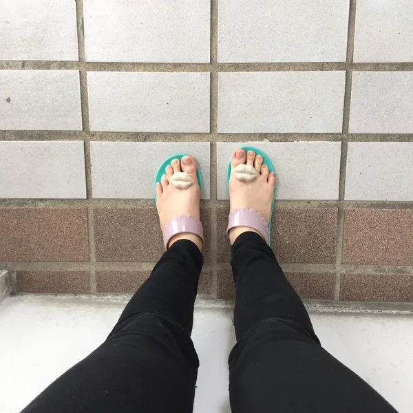 Sección baja de la mujer con zapatillas verde de pie en el suelo a pie —  Fotos de Stock