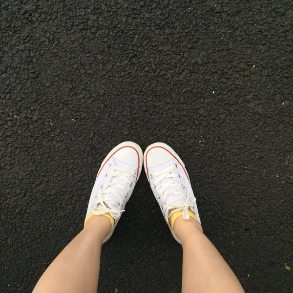 Gros plan de jambes femme avec jambe et baskets blanches en plein air — Photo