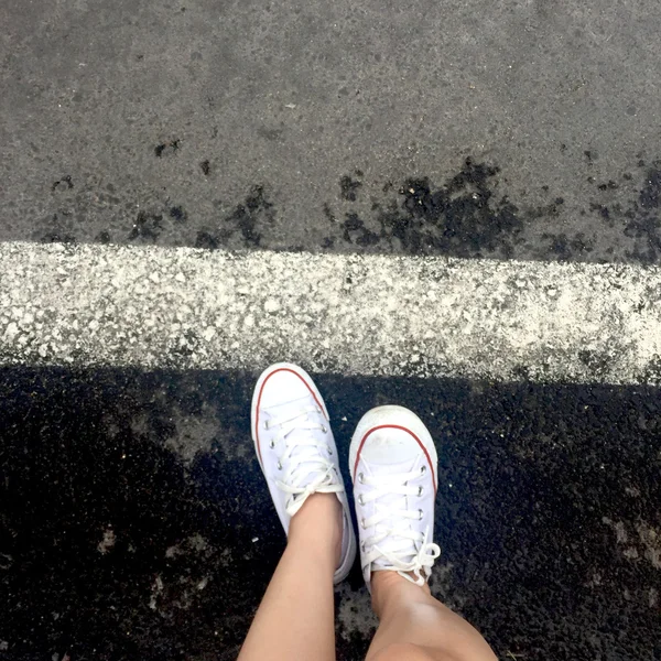 Zbliżenie zewnątrz życia nogi nastolatkę. Hipster młoda kobieta w jej białe trampki — Zdjęcie stockowe