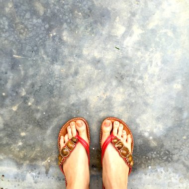 Giyen kadın ayakları yere floplar flip. üstten görünüm 