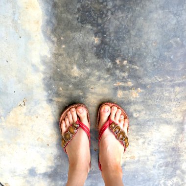 Giyen kadın ayakları yere floplar flip. üstten görünüm 