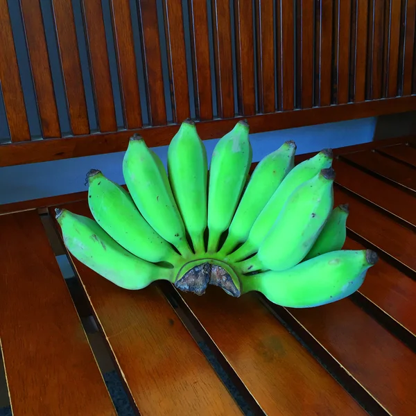 Πράσινων μπανανών δέσμη σε ένα ξύλο παρασκήνιο — Φωτογραφία Αρχείου