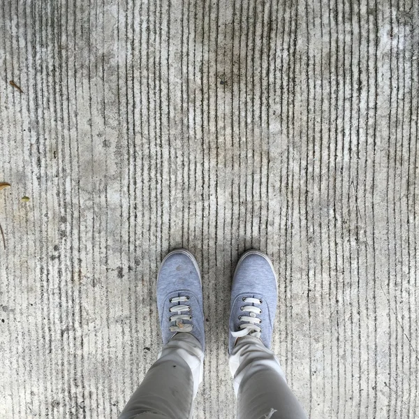 Γκρι πάνινα παπούτσια Περπάτημα στο πάτωμα — Φωτογραφία Αρχείου